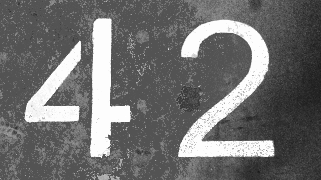 Die Zahl 42 weiß auf grauem Beton geschrieben.
